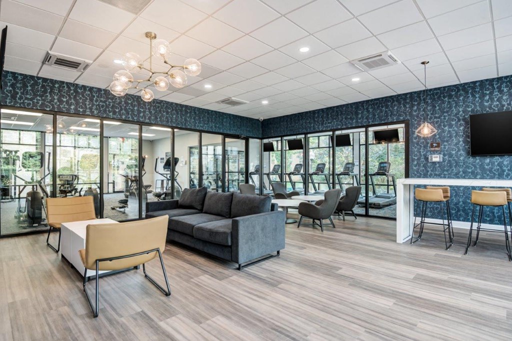 a lounge area with a couch and chairs and a tv