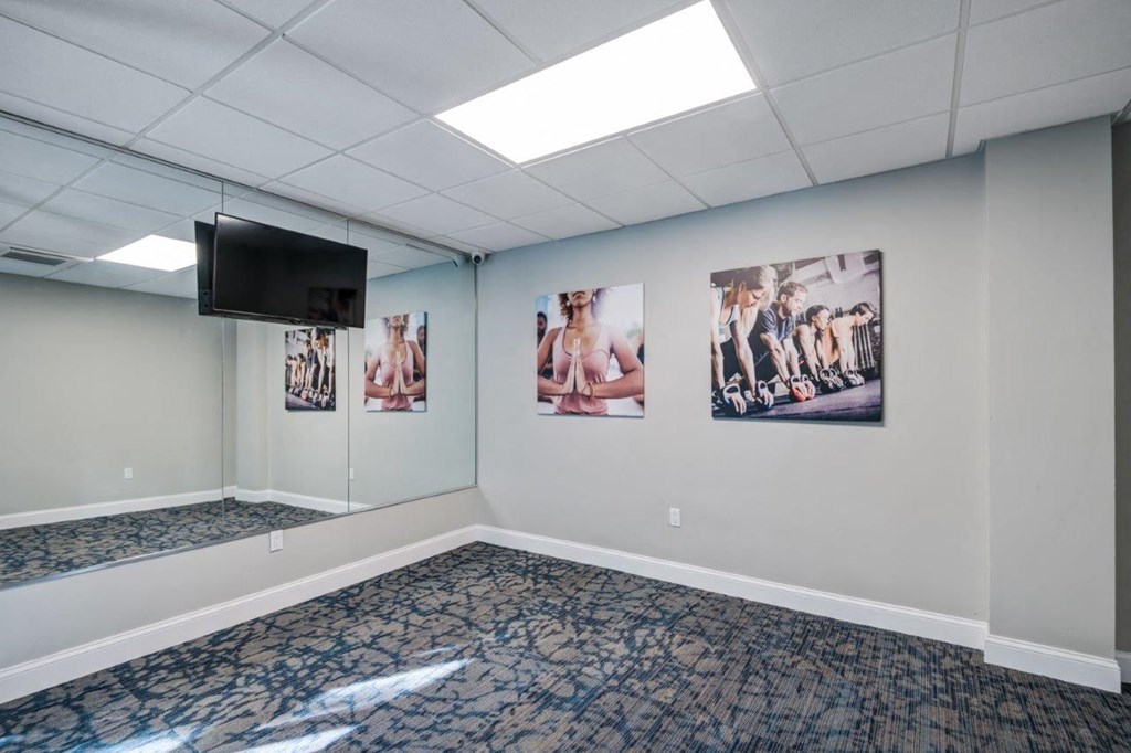 an empty room with pictures on the wall and a television