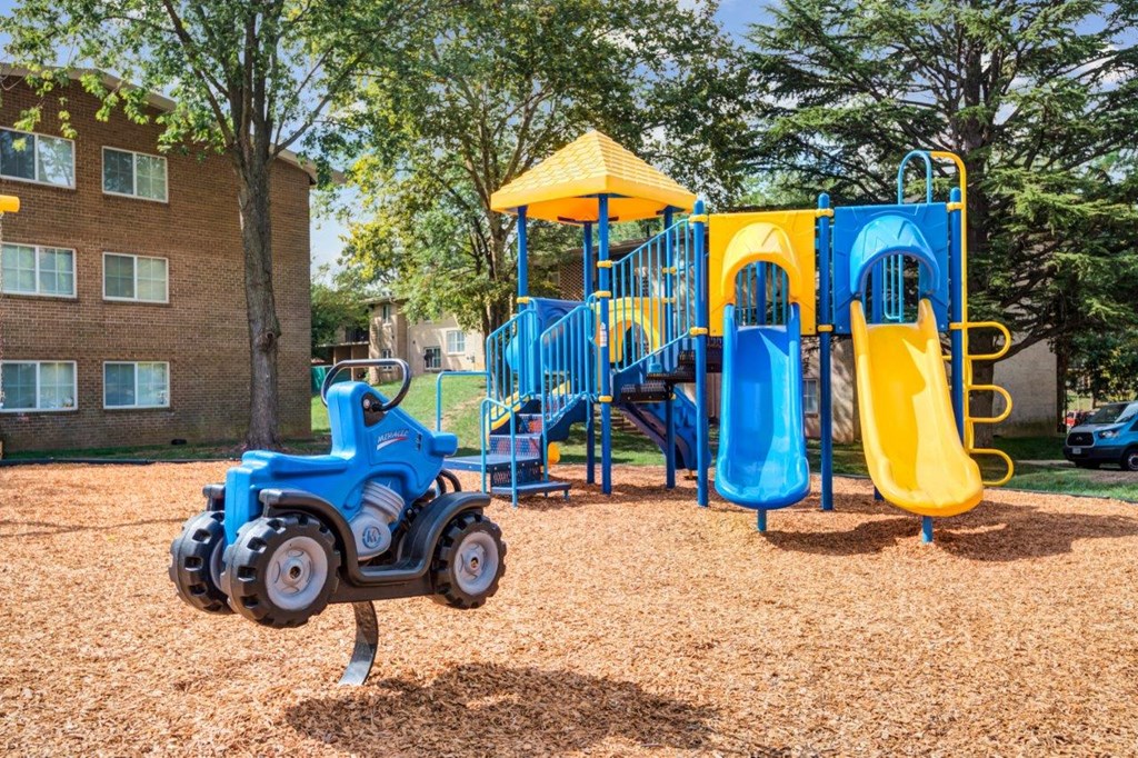 a playground with a blue and yellow swing set    and a yellow swing
