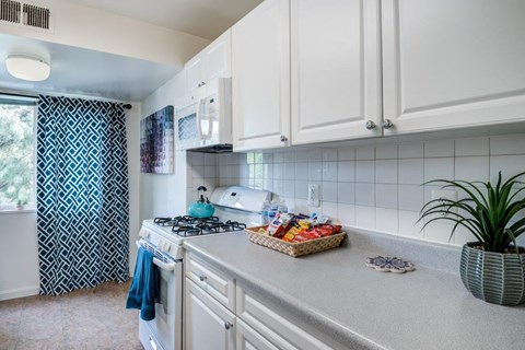 a white kitchen with a basket of food on the counter