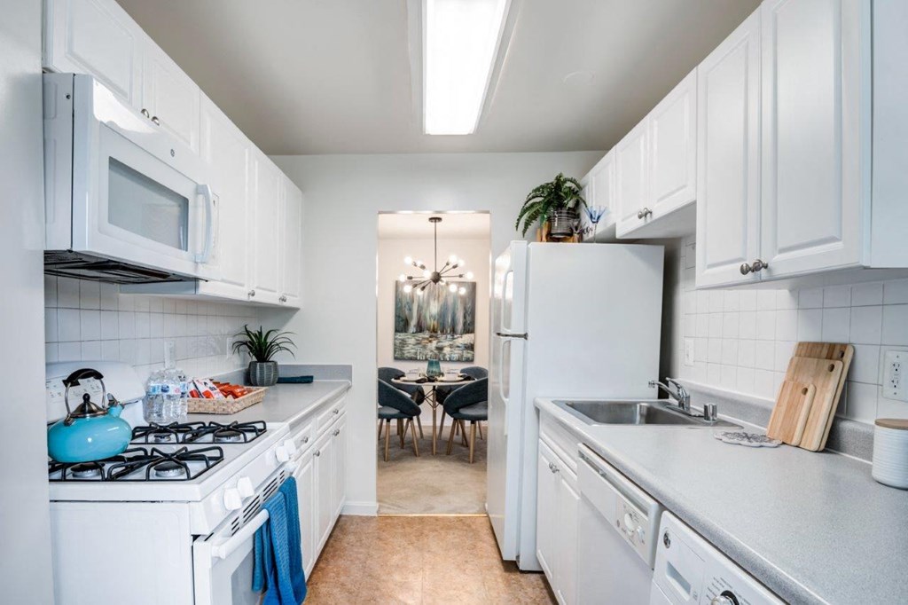 a kitchen with white cabinets and a white refrigerator