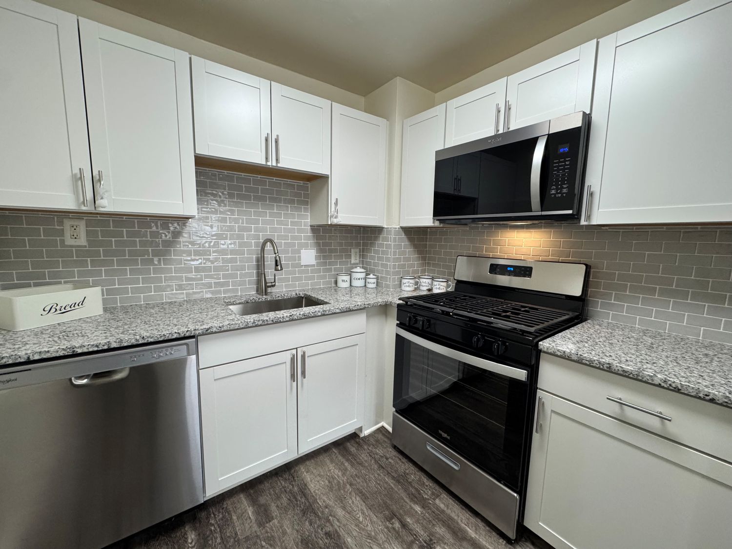 A kitchen with white cabinets and a black stove top oven.