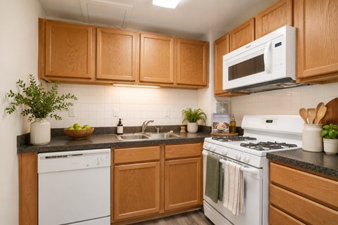 A kitchen with wooden cabinets and white appliances.