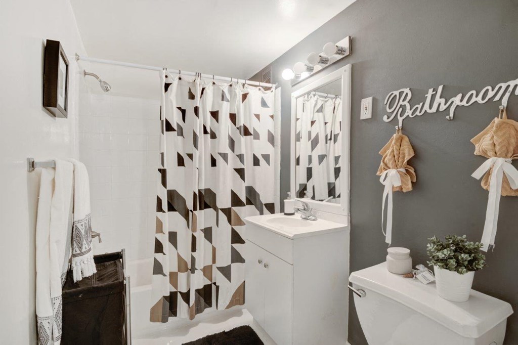 a bathroom with a shower curtain and a toilet and a sink
