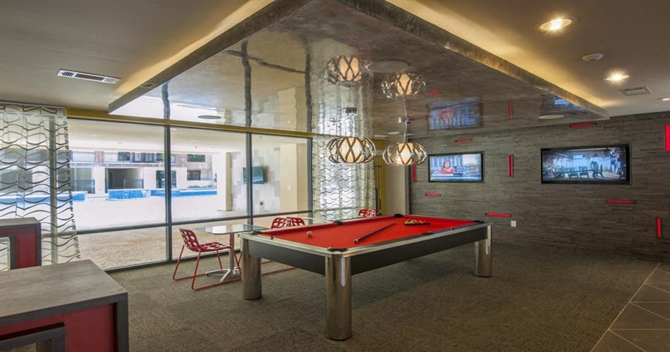 a red pool table in a room with a tv