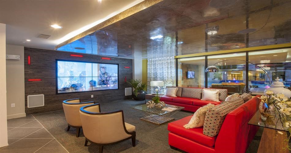 a living room with a red couch and chairs and a television