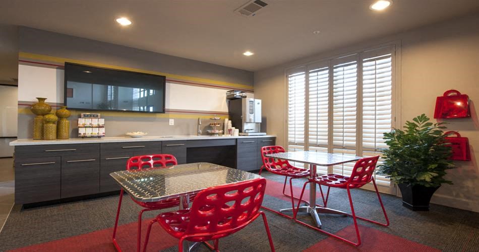 a kitchen and dining room with red chairs and a table