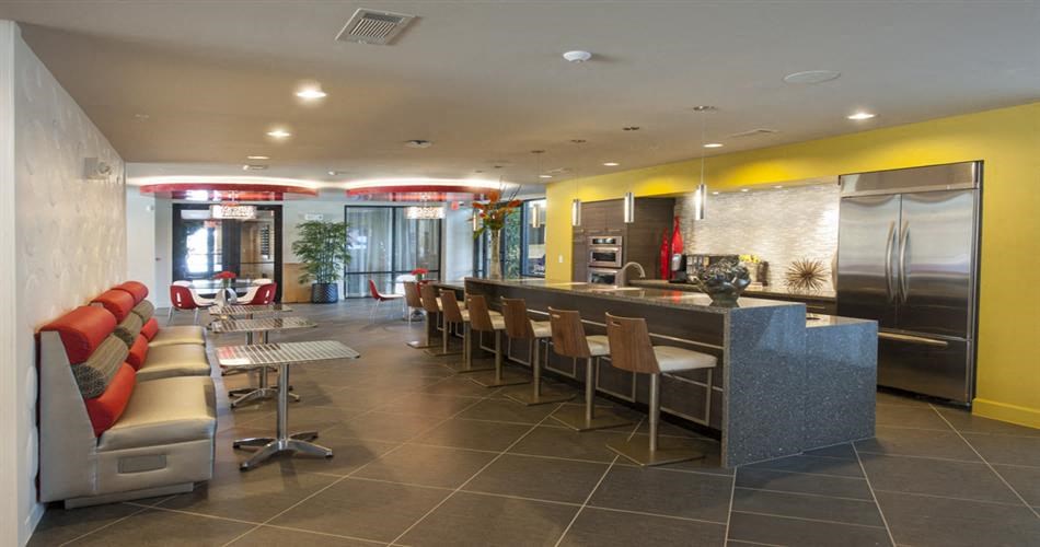 a lobby with a bar and chairs and a kitchen