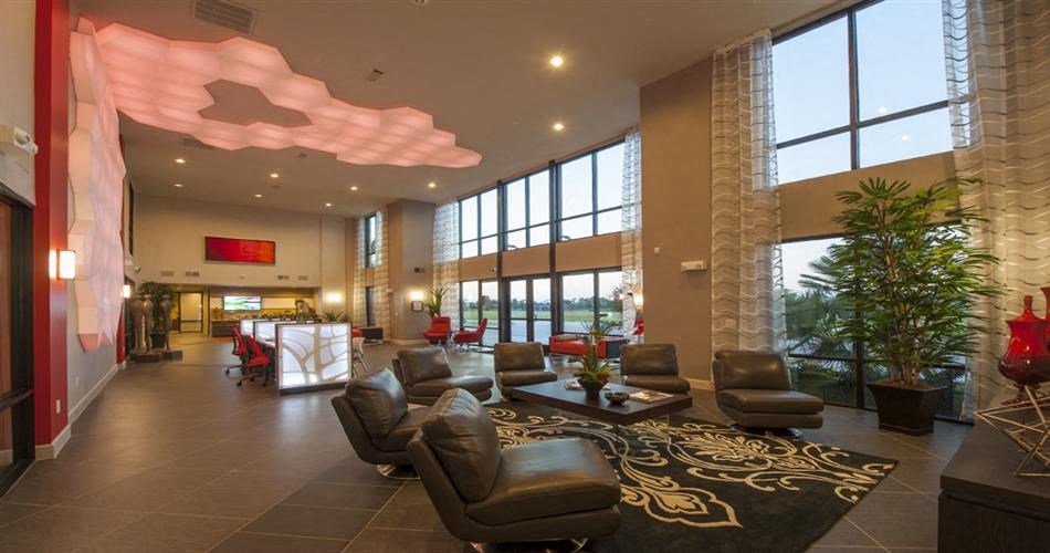 a lobby of a hotel with chairs and a rug