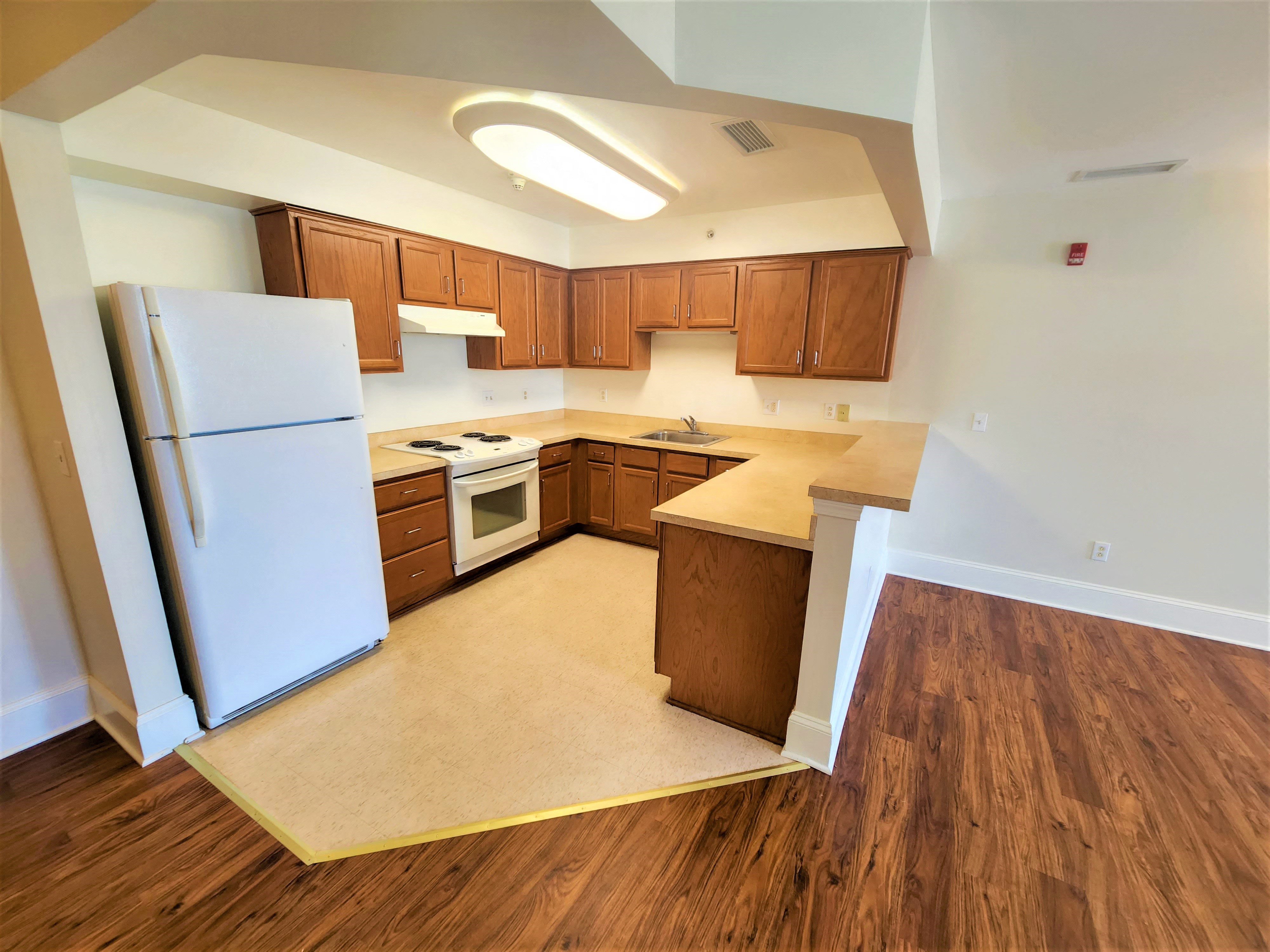 a kitchen with wood flooring and a white refrigerator