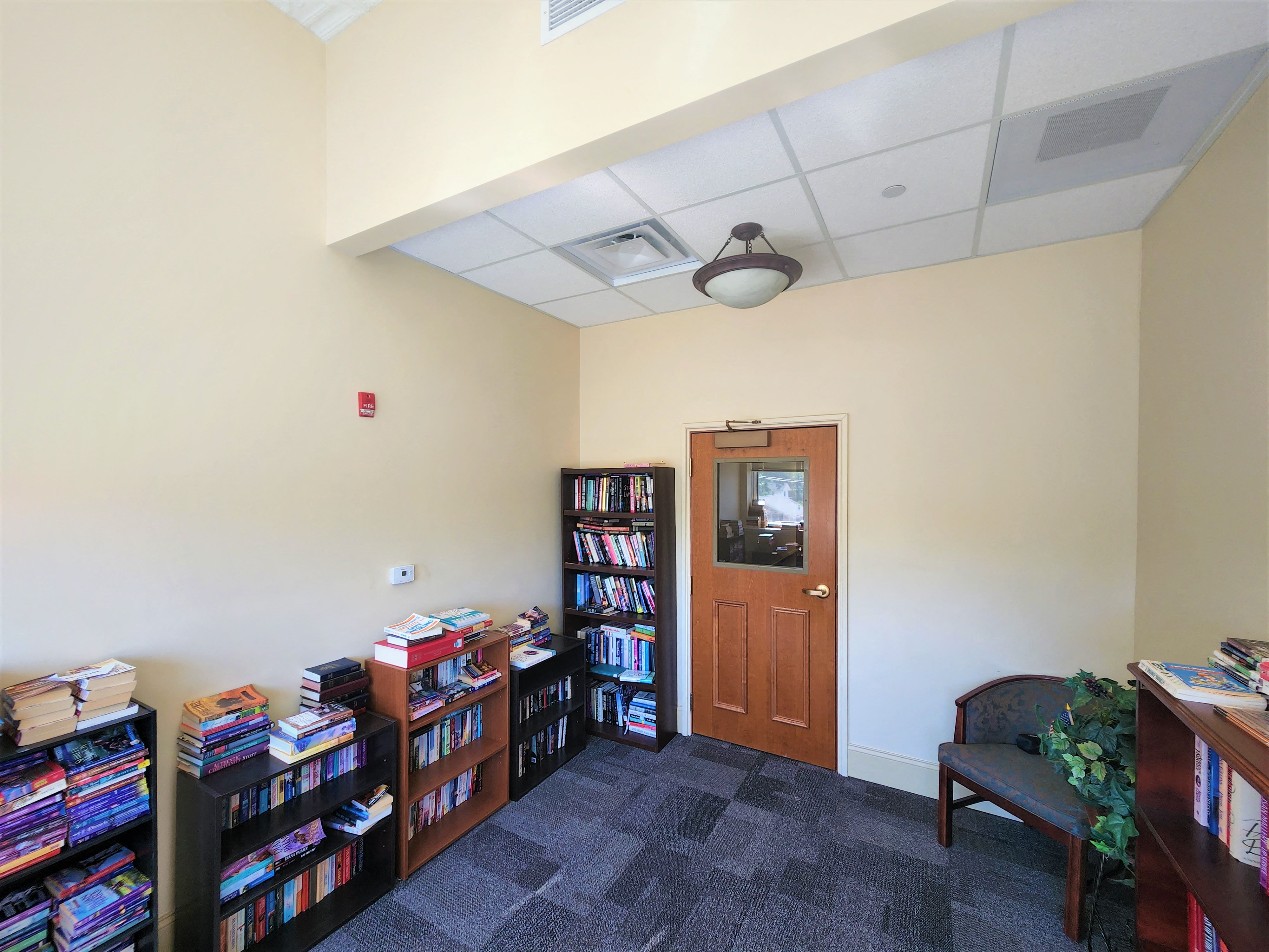 a library with a door and bookshelves filled with books