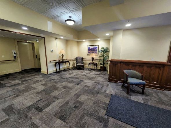 a lobby with chairs and a table in a building