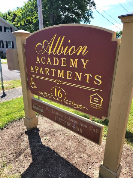 a sign in front of a house that says apartments