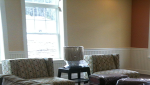 a living room with chairs and a fireplace