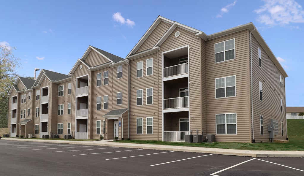 an image of an apartment building with a parking lot