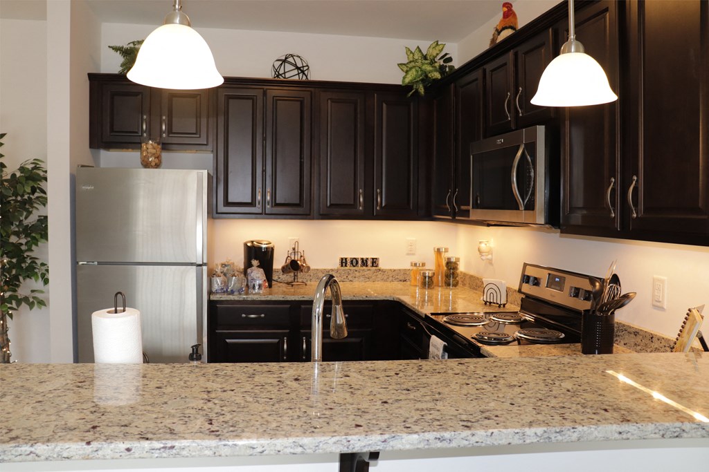 a kitchen with granite counter tops and black cabinets