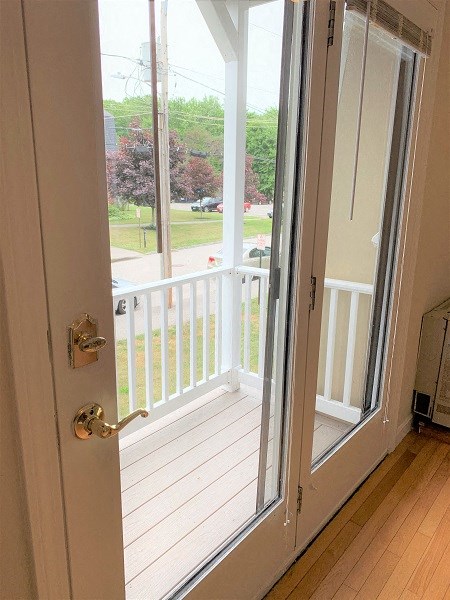 A white door with a glass window is open.
