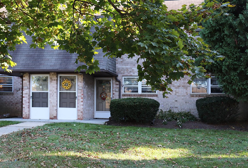 a brick house with a tree in front of it