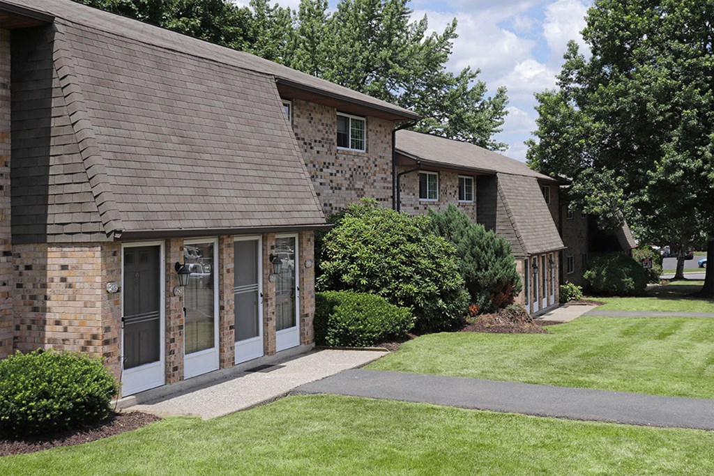 a building with a lawn and a sidewalk in front of it