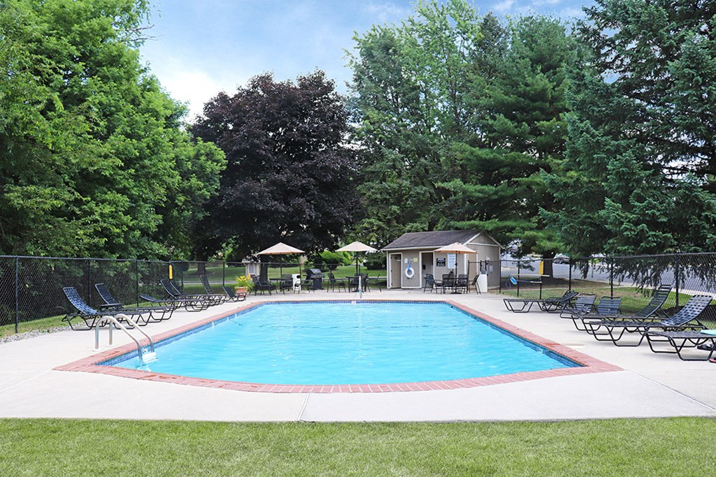 a swimming pool with chairs and a fence around it