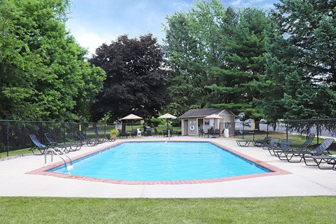 a swimming pool with chairs and a fence around it