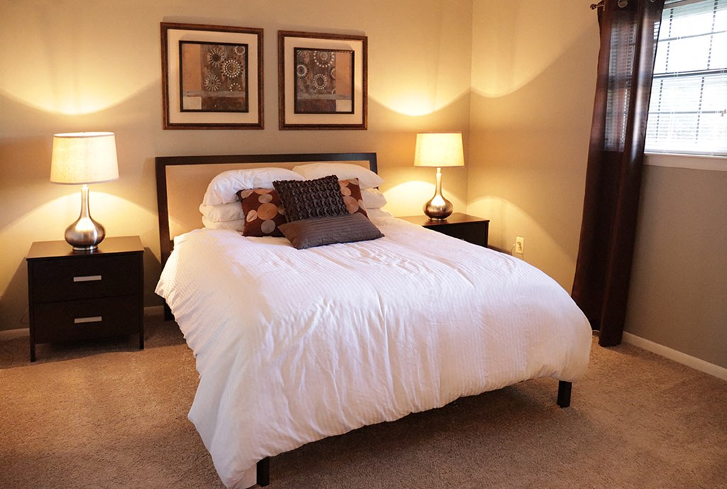 a bedroom with a white bed and two lamps