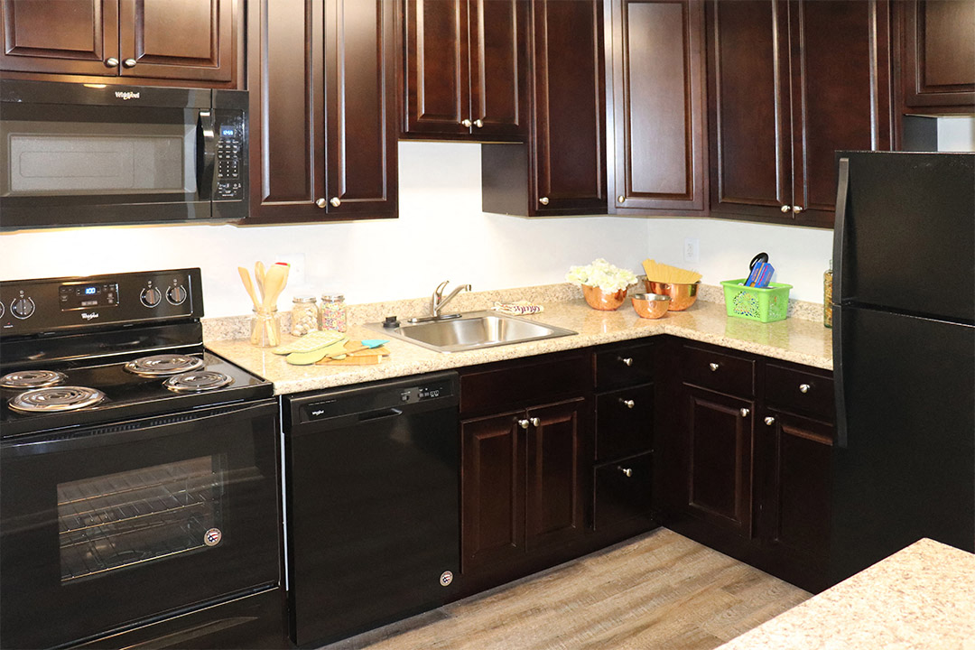a kitchen with black appliances and brown cabinets