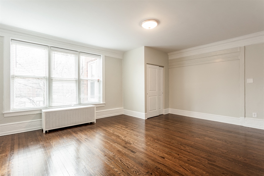 an empty living room with wood floors and a window