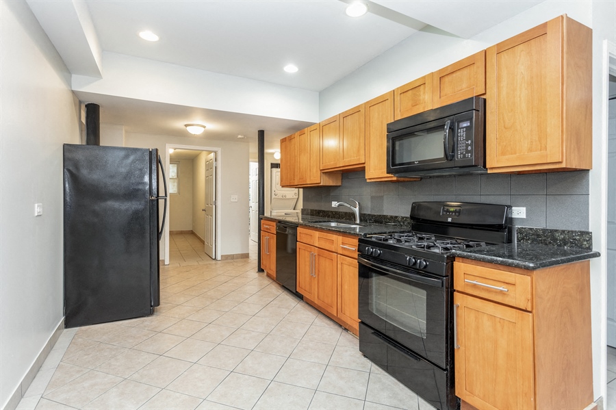a kitchen with black appliances and wooden cabinets