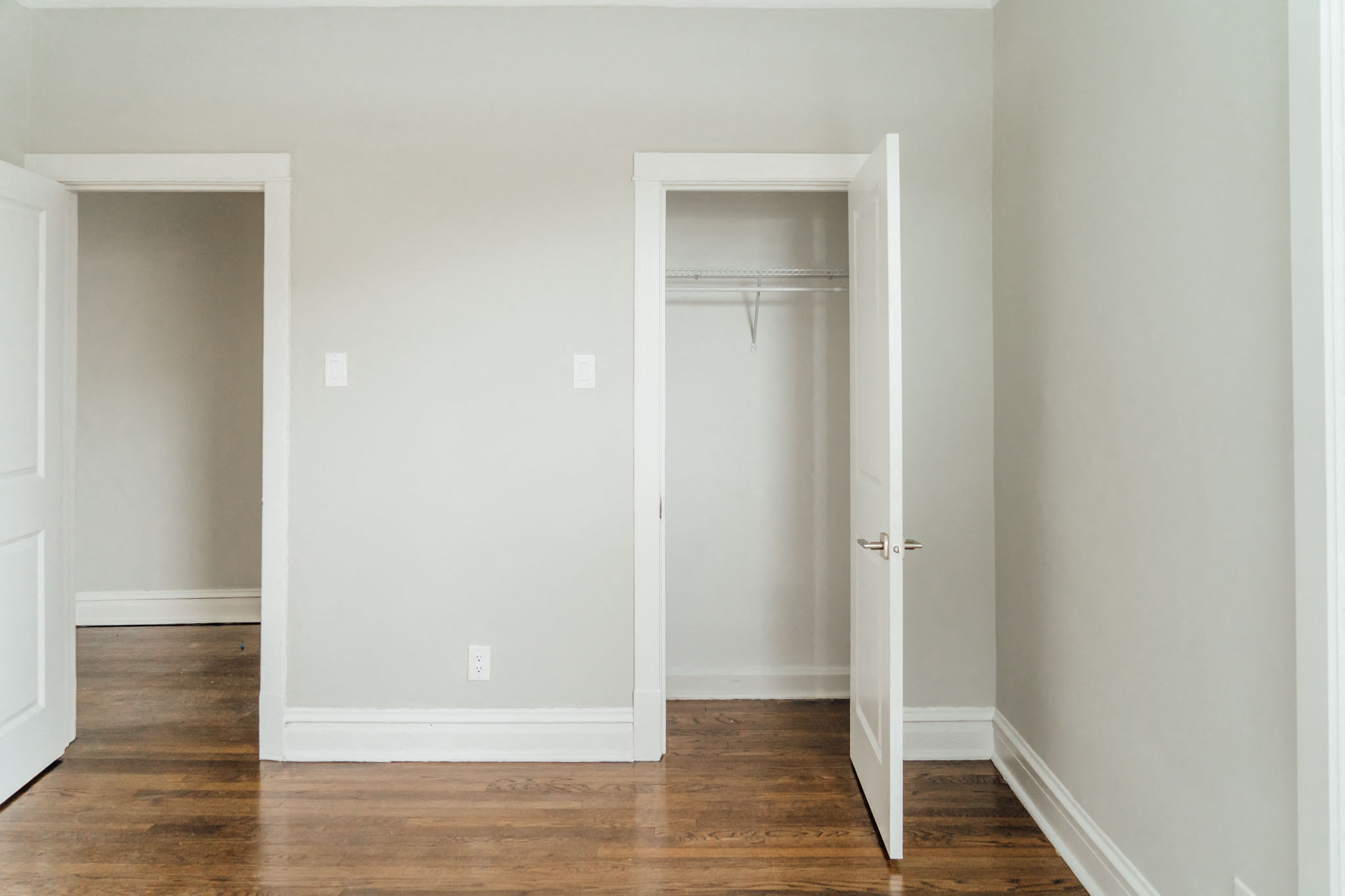 an empty room with a closet and a hard wood floor
