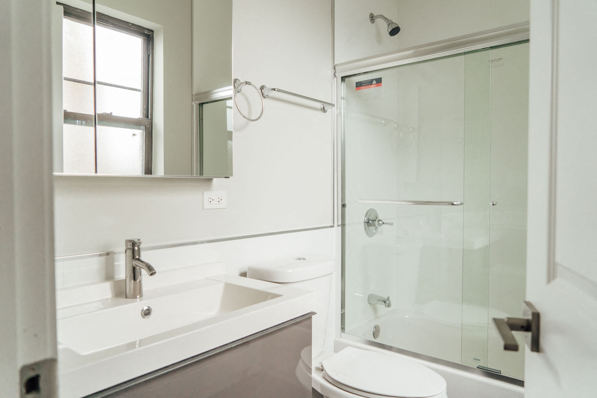 a white bathroom with a shower sink and toilet