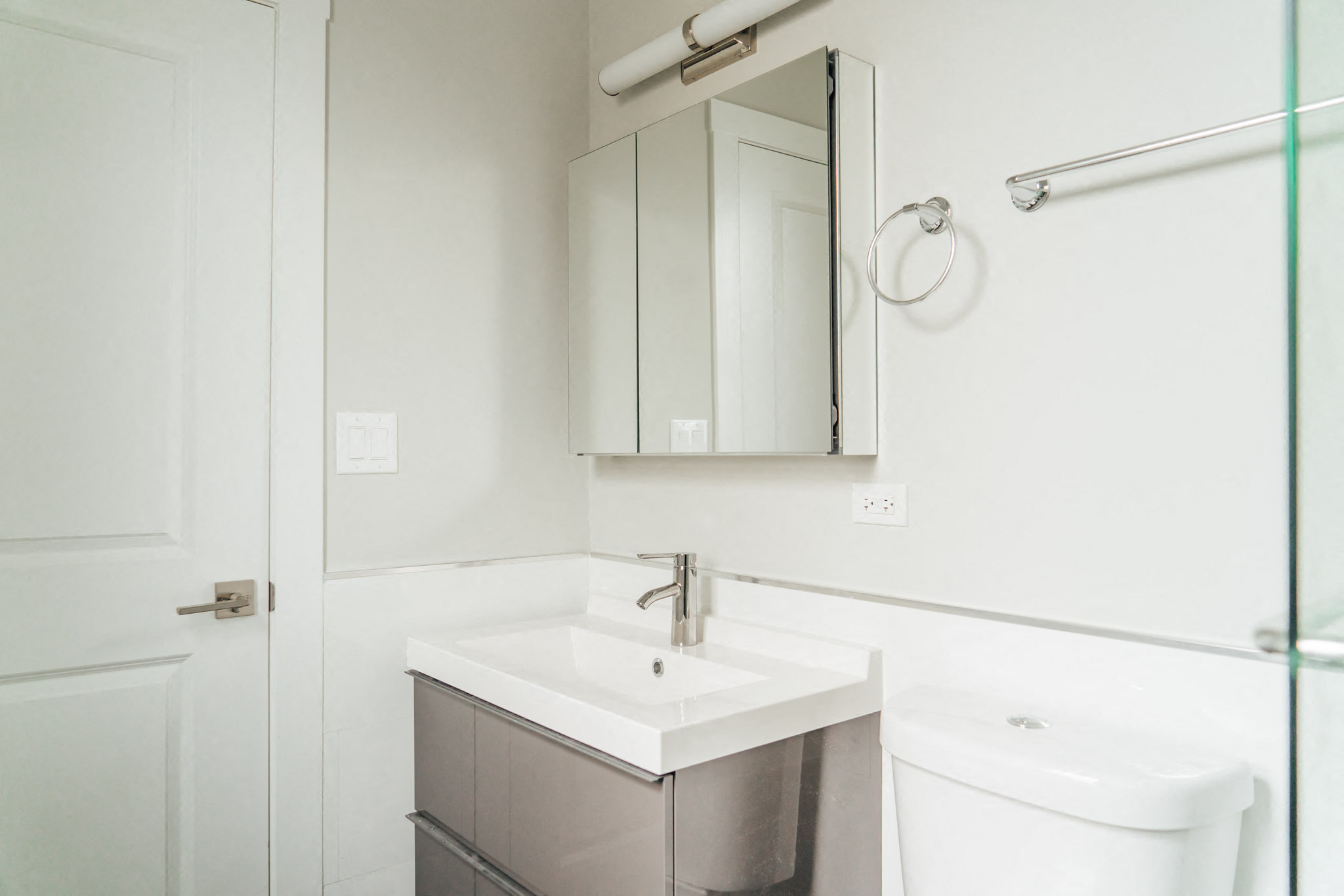 a white bathroom with a sink and a mirror