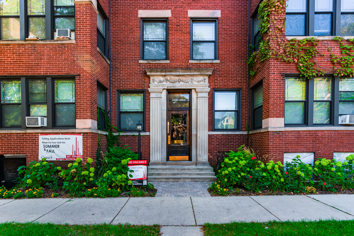 the front of a brick building with a sidewalk in front of it