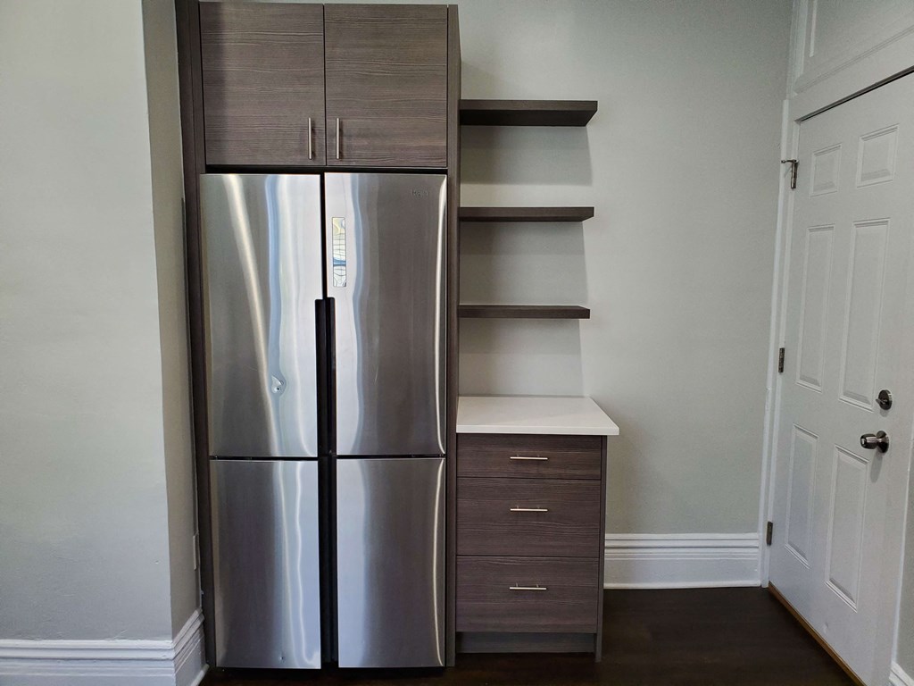 a kitchen with a stainless steel refrigerator and shelves
