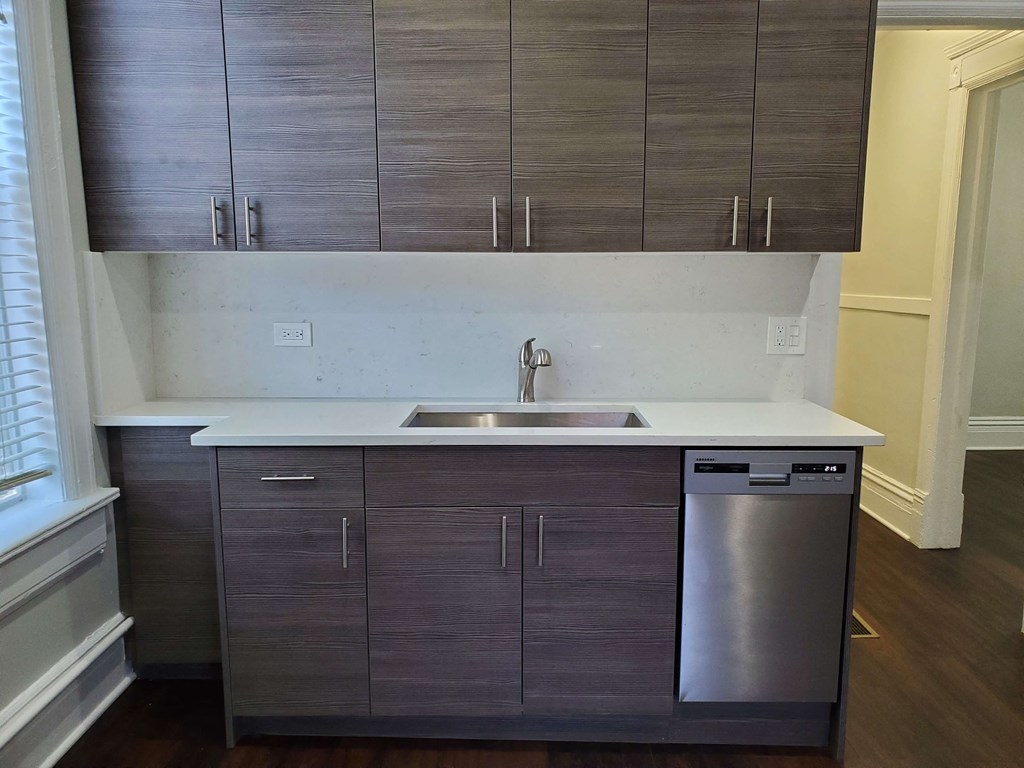 an empty kitchen with a sink and cabinets