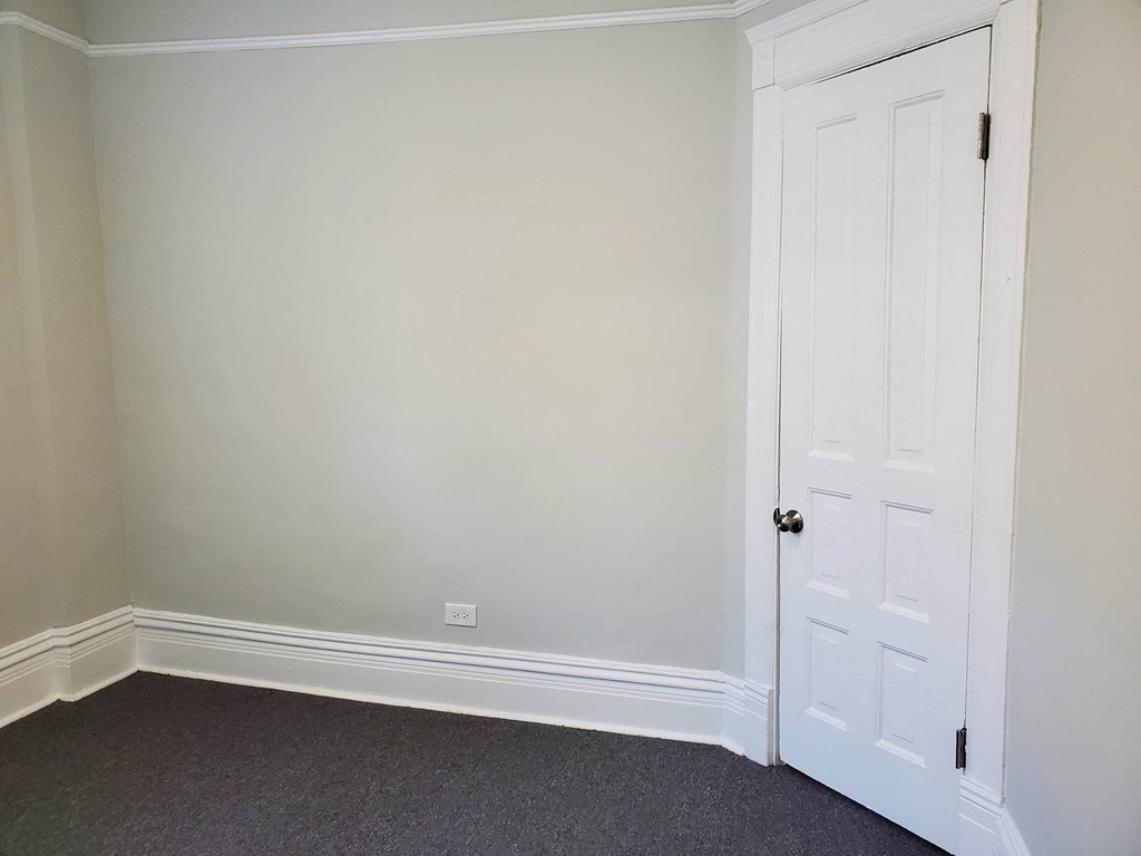 a bedroom with white walls and a white door