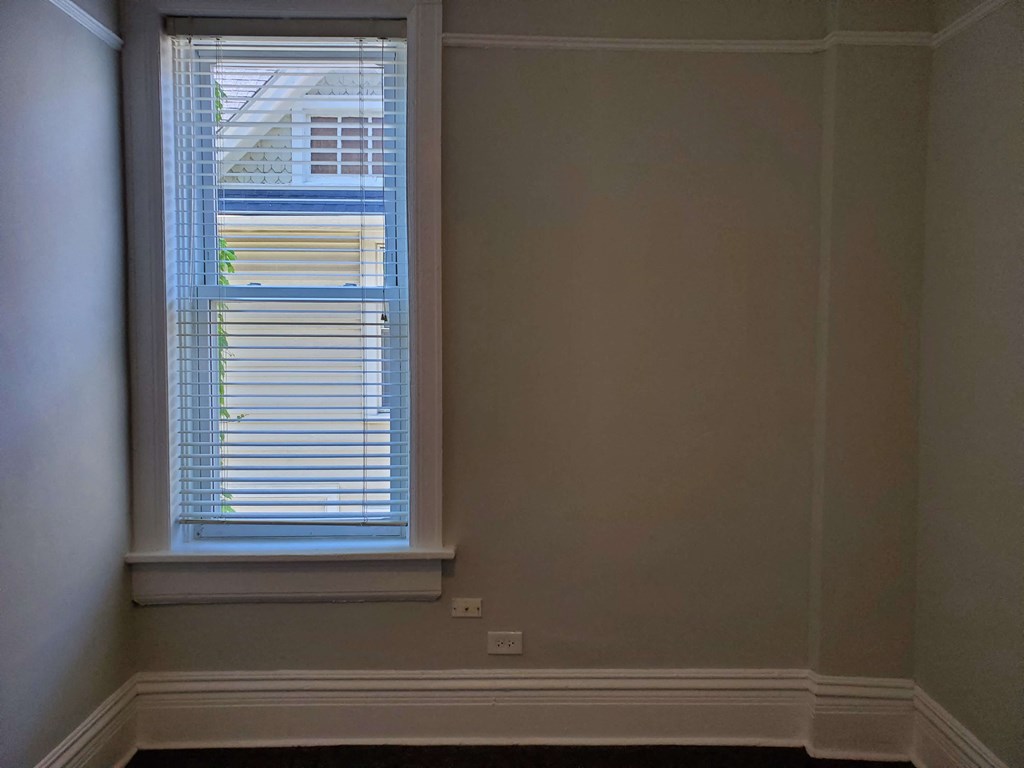 the corner of a room with a window and white walls