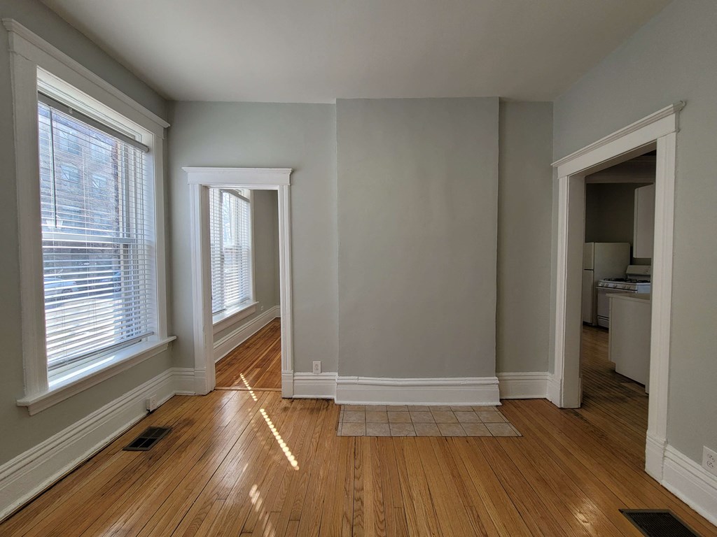 the living room and dining room of an empty house with wood floors
