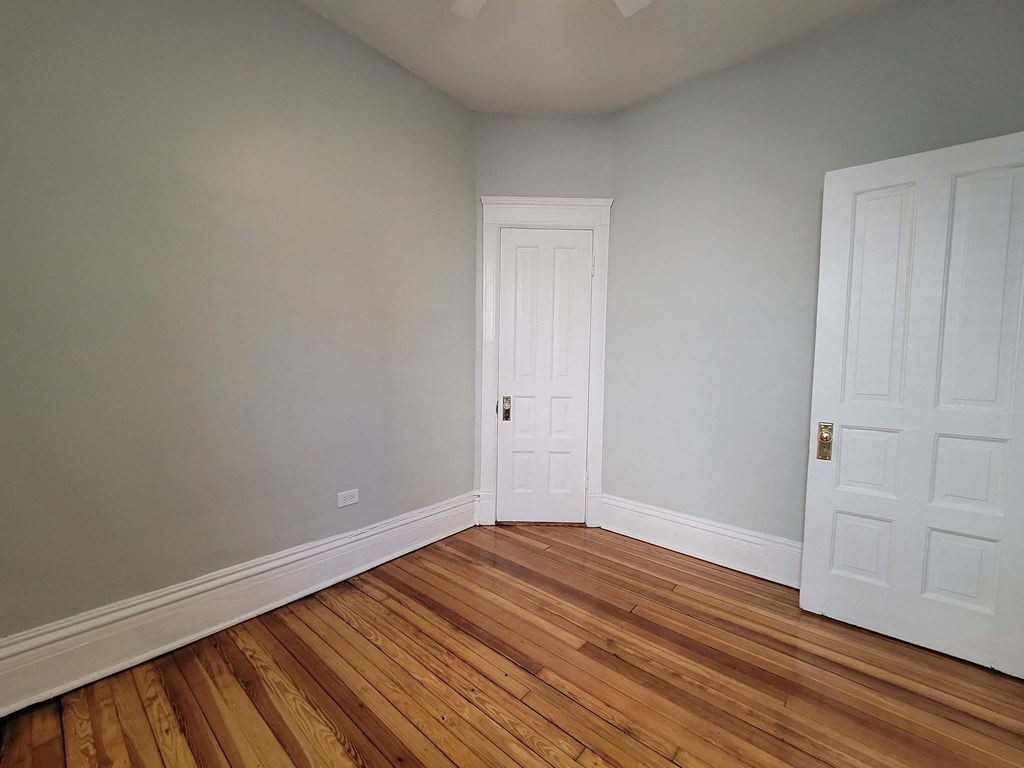 a room with wooden floors and a white door