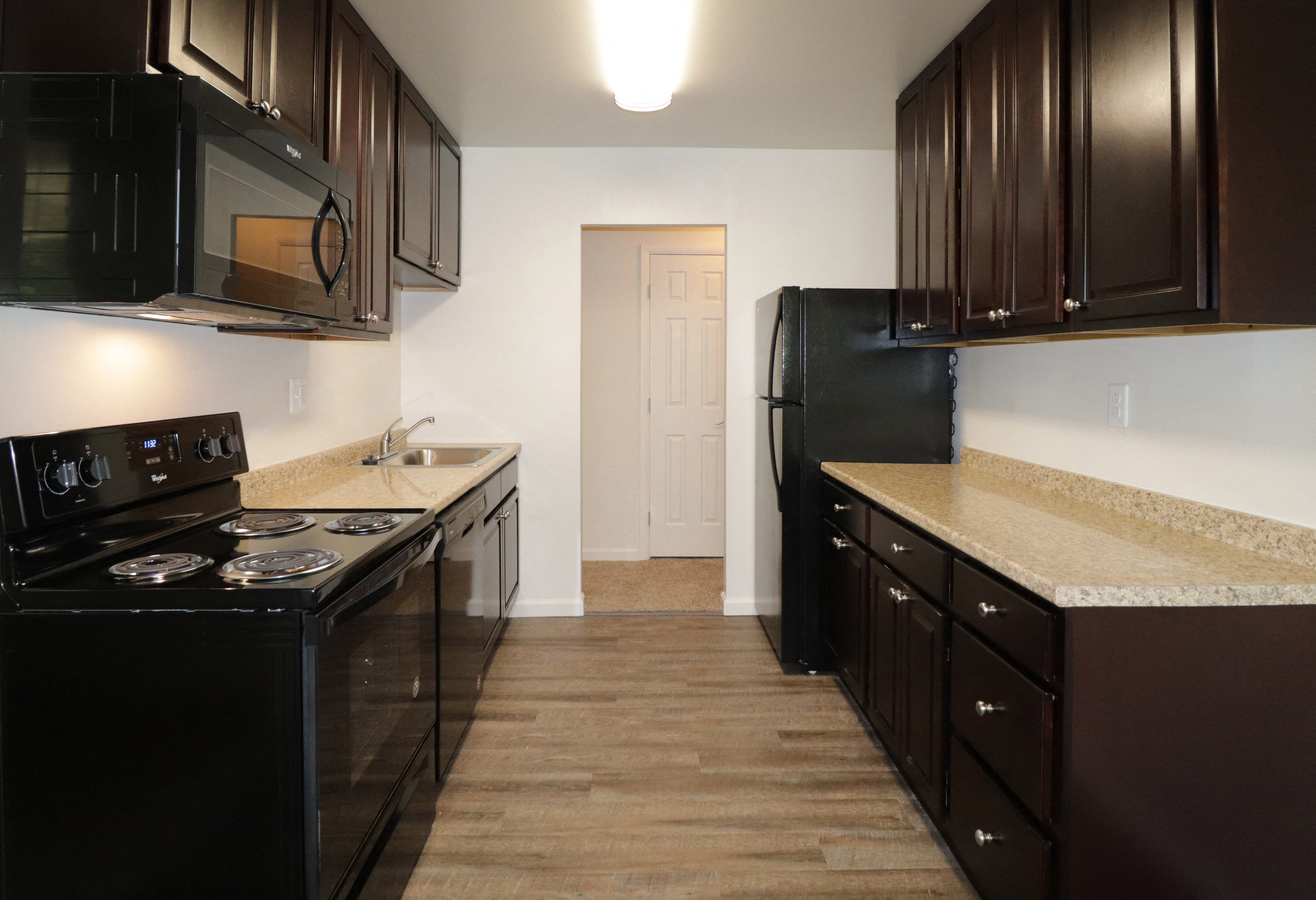 a kitchen with black appliances and granite counter tops and a black refrigerator