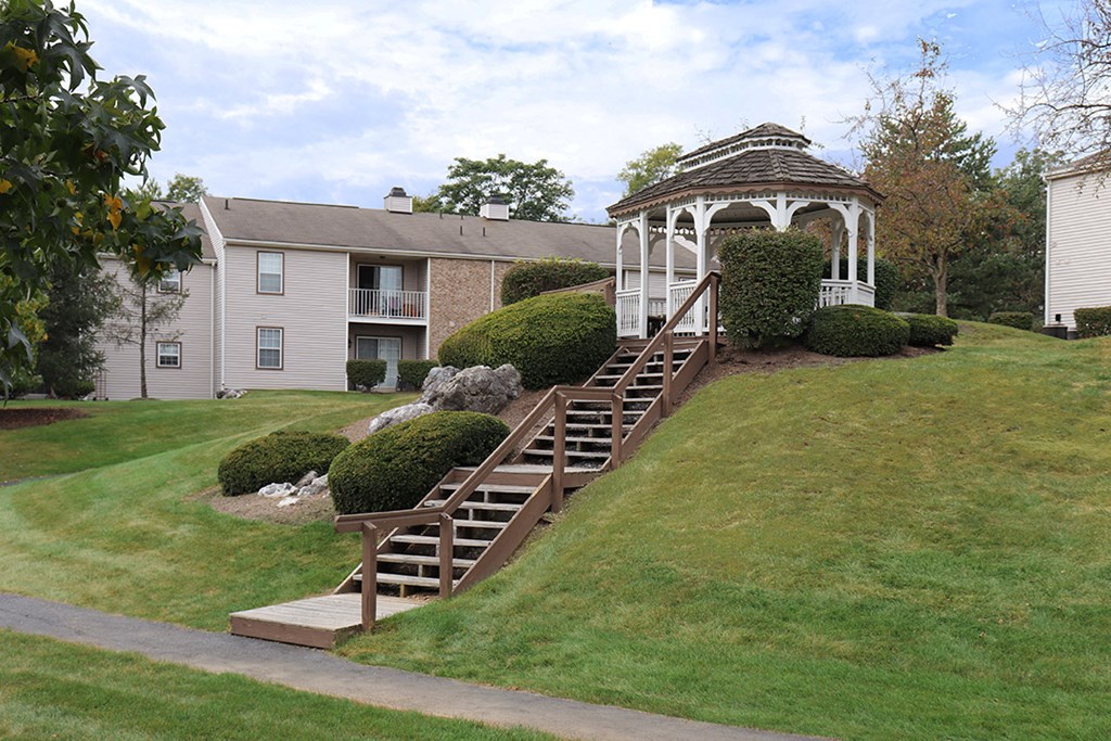 a gazebo on a hill in a yard with stairs