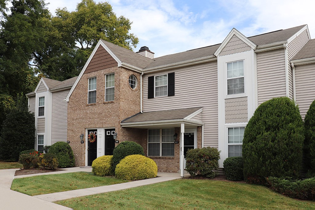 the view of a house with a sidewalk in front of it