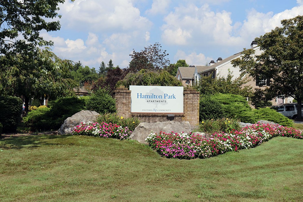 the sign for harmon park in front of a building with flowers