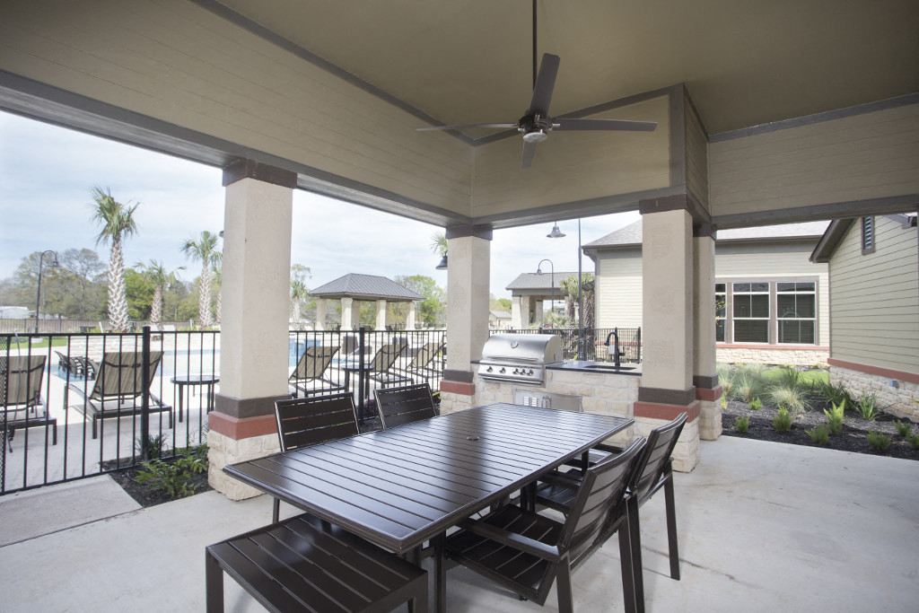 a patio with a table and chairs and a ceiling fan
