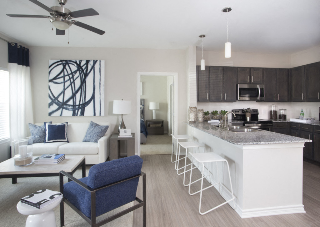 a kitchen and living room with a bar and a living room