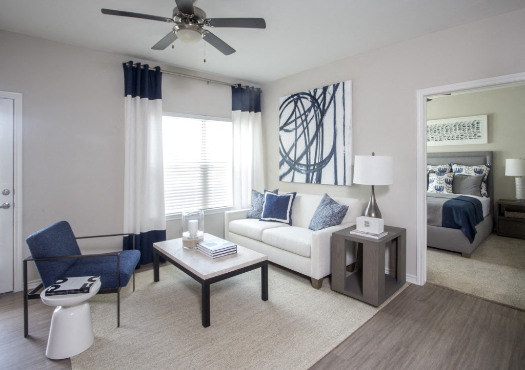 a living room with a couch and a coffee table and a ceiling fan