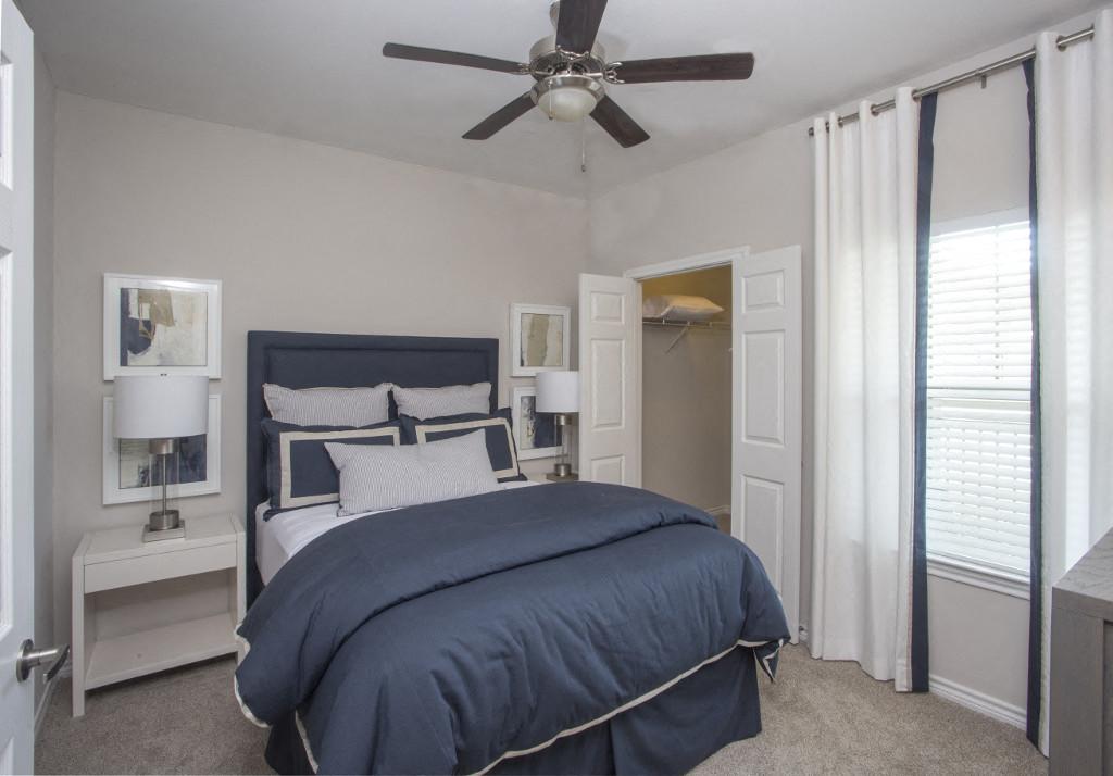 a bedroom with a bed and a ceiling fan