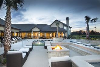 a swimming pool with a fire pit in front of a house
