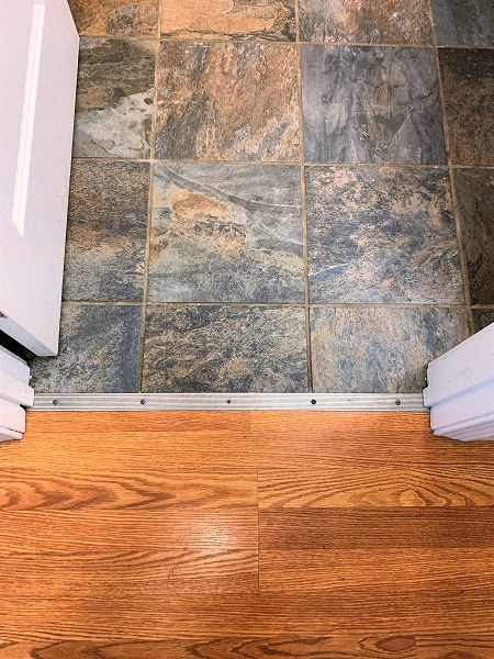A bathroom with a wooden floor and stone tiles.