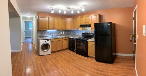 A kitchen with wooden cabinets and black appliances.